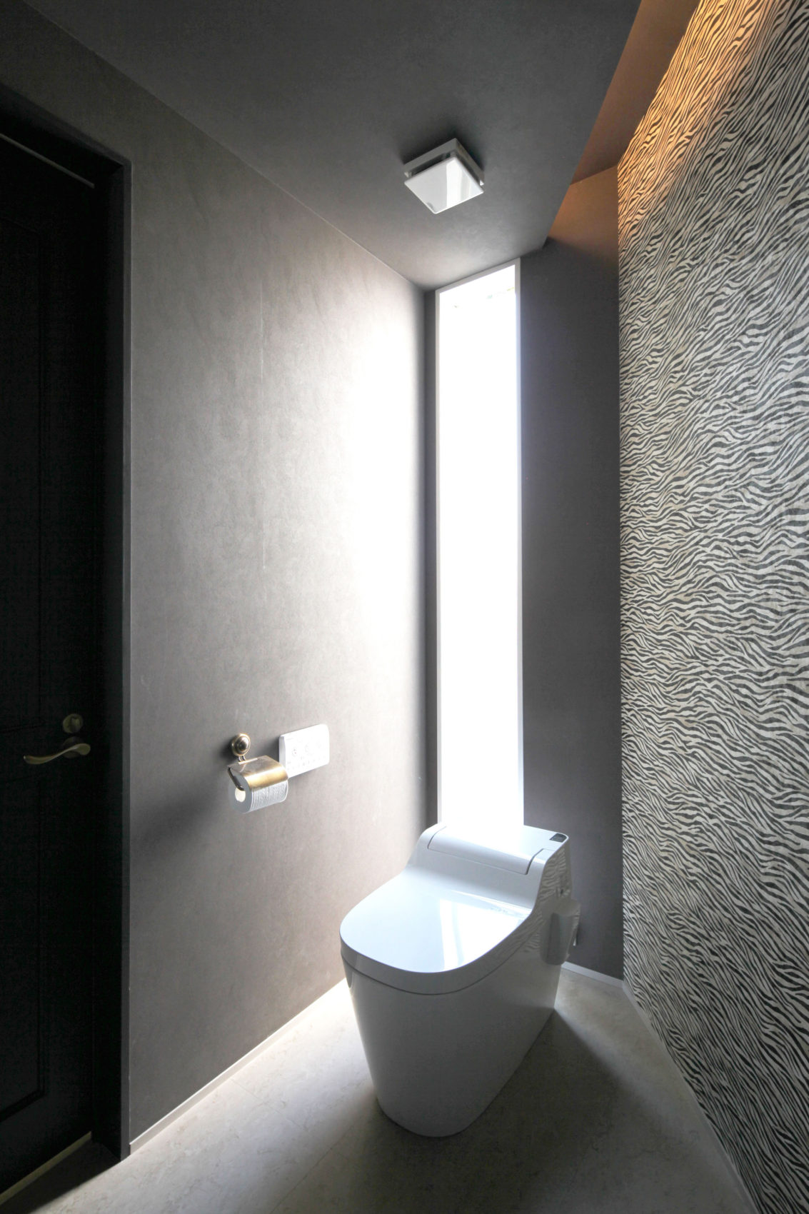 壁紙が印象的なトイレとスリット窓